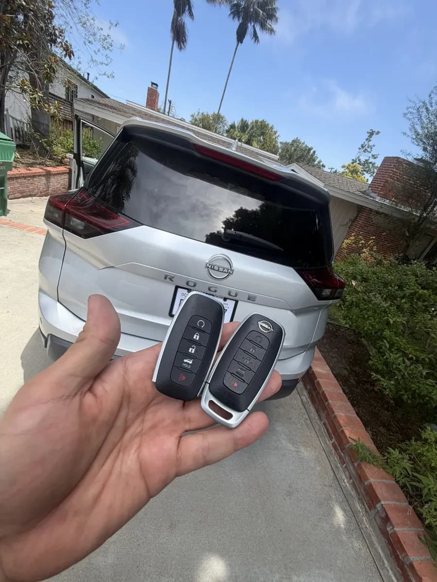 Two Nissan Rogue smart keys in a Point Loma driveway