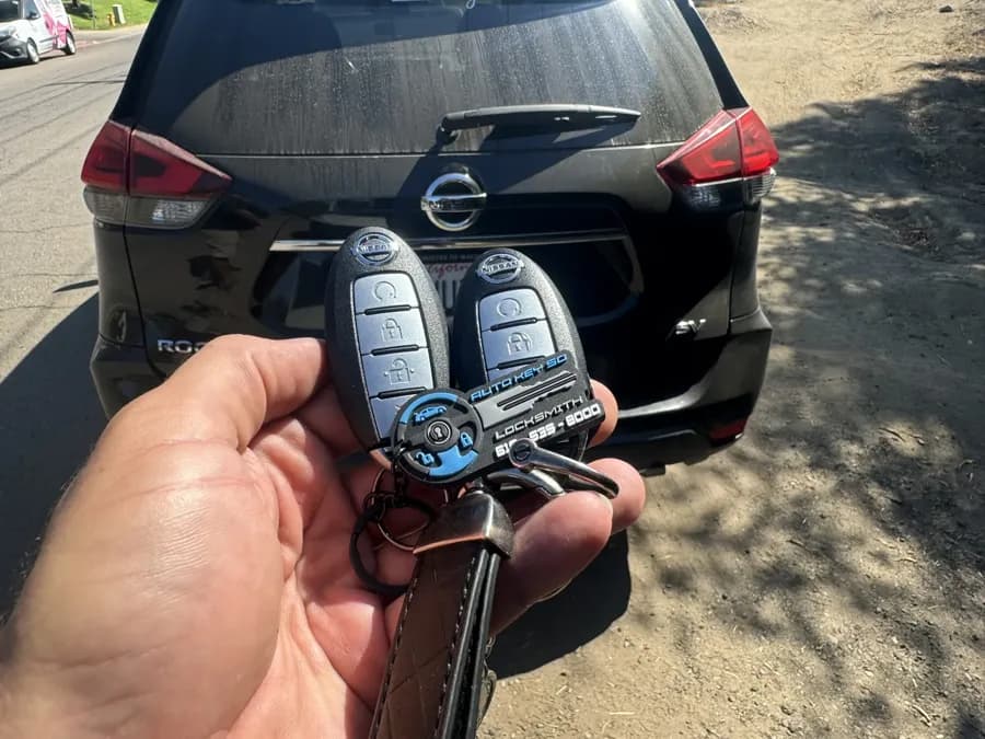 Two Nissan Rogue smart keys held behind the vehicle