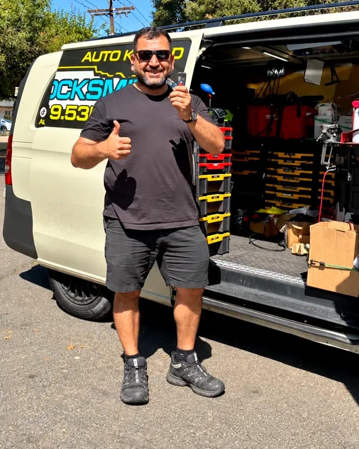 Saif, owner of Auto Key SD, holding a key beside his open mobile locksmith van