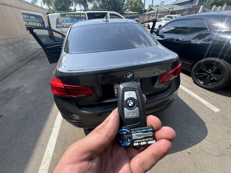 BMW smart key held behind a BMW 328i with the Auto Key SD van