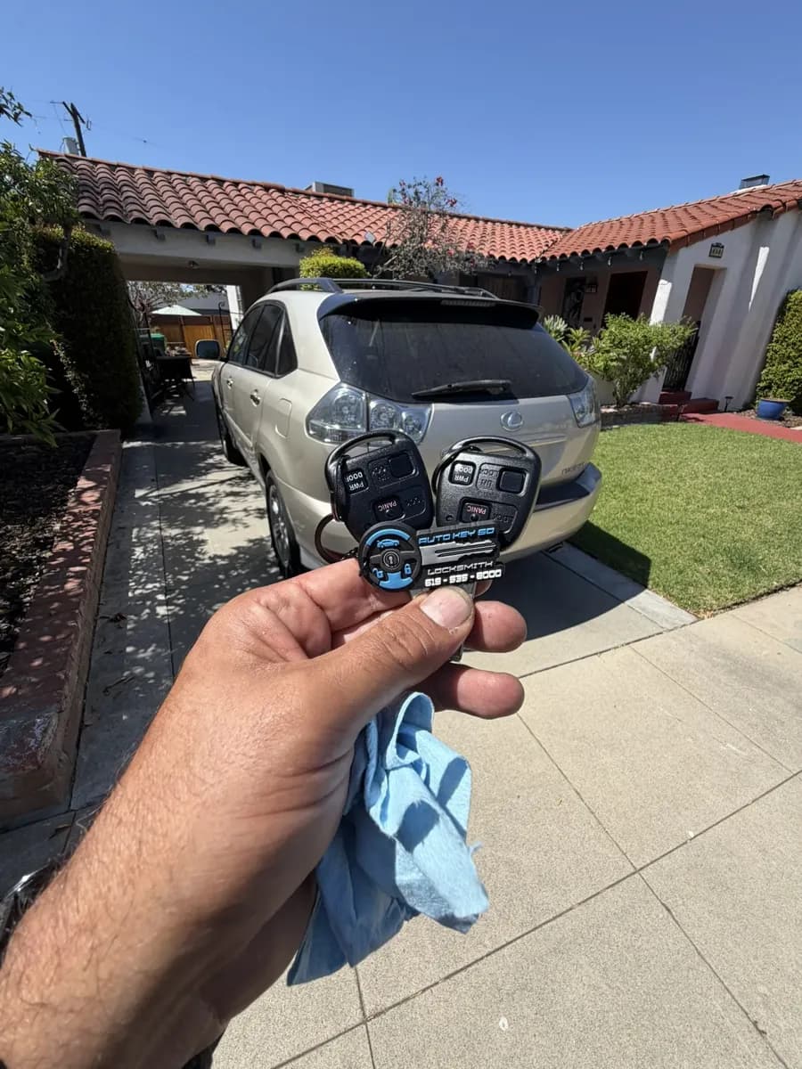 Two Lexus RX remote-head keys held in front of the vehicle