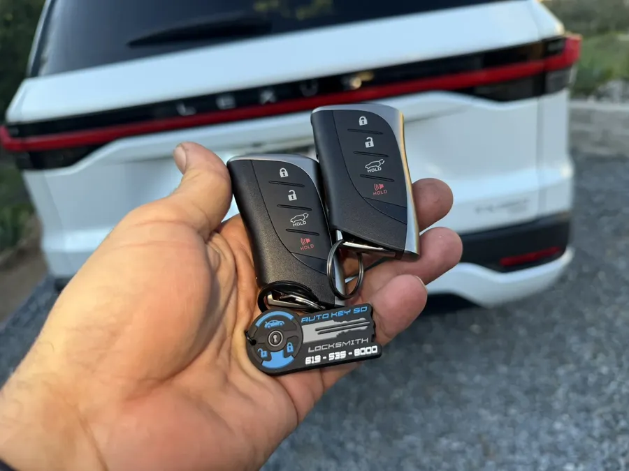 Two Lexus TX smart keys held behind the vehicle